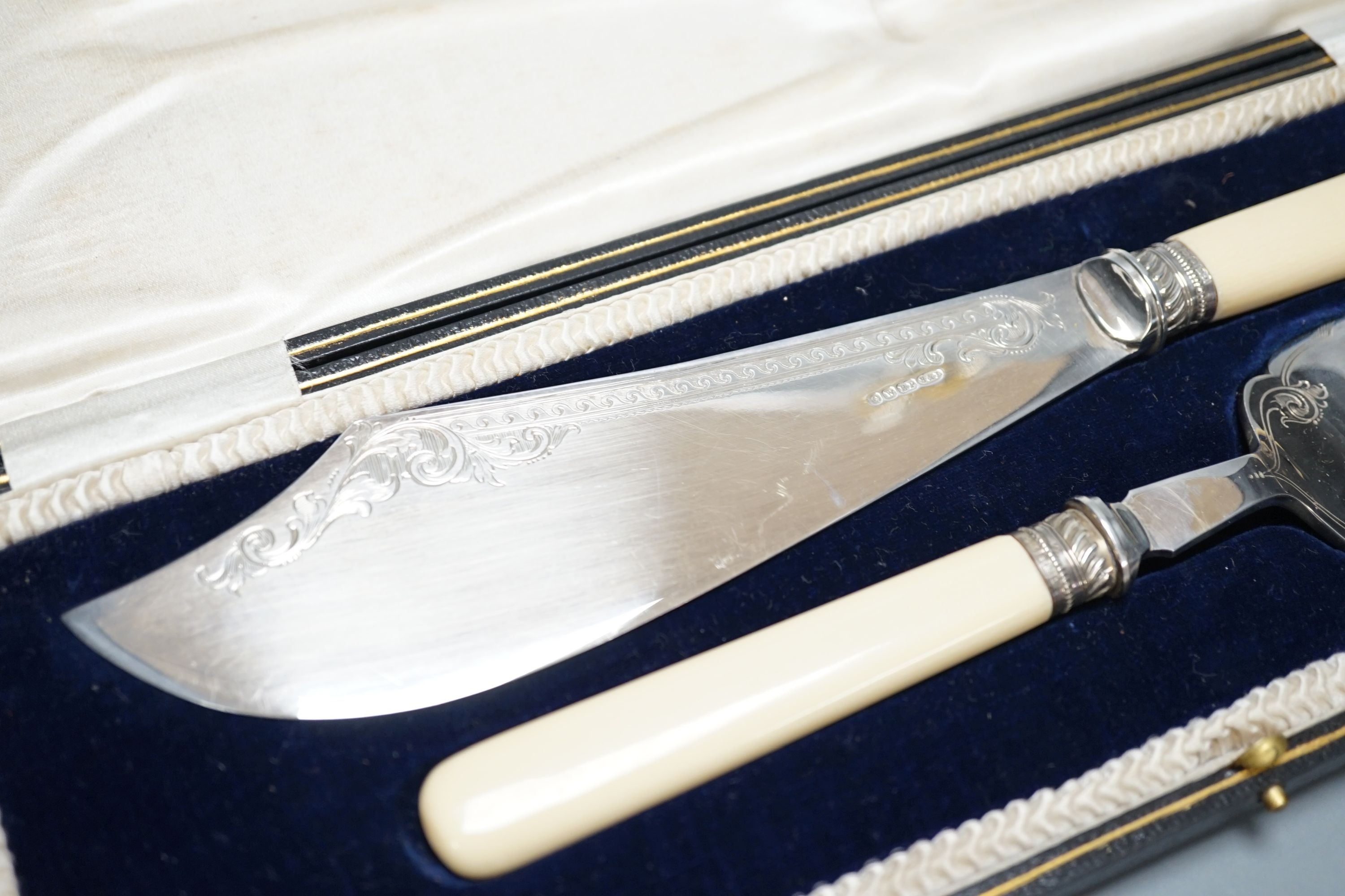 A cased pair of ivory handled silver plated fish servers.